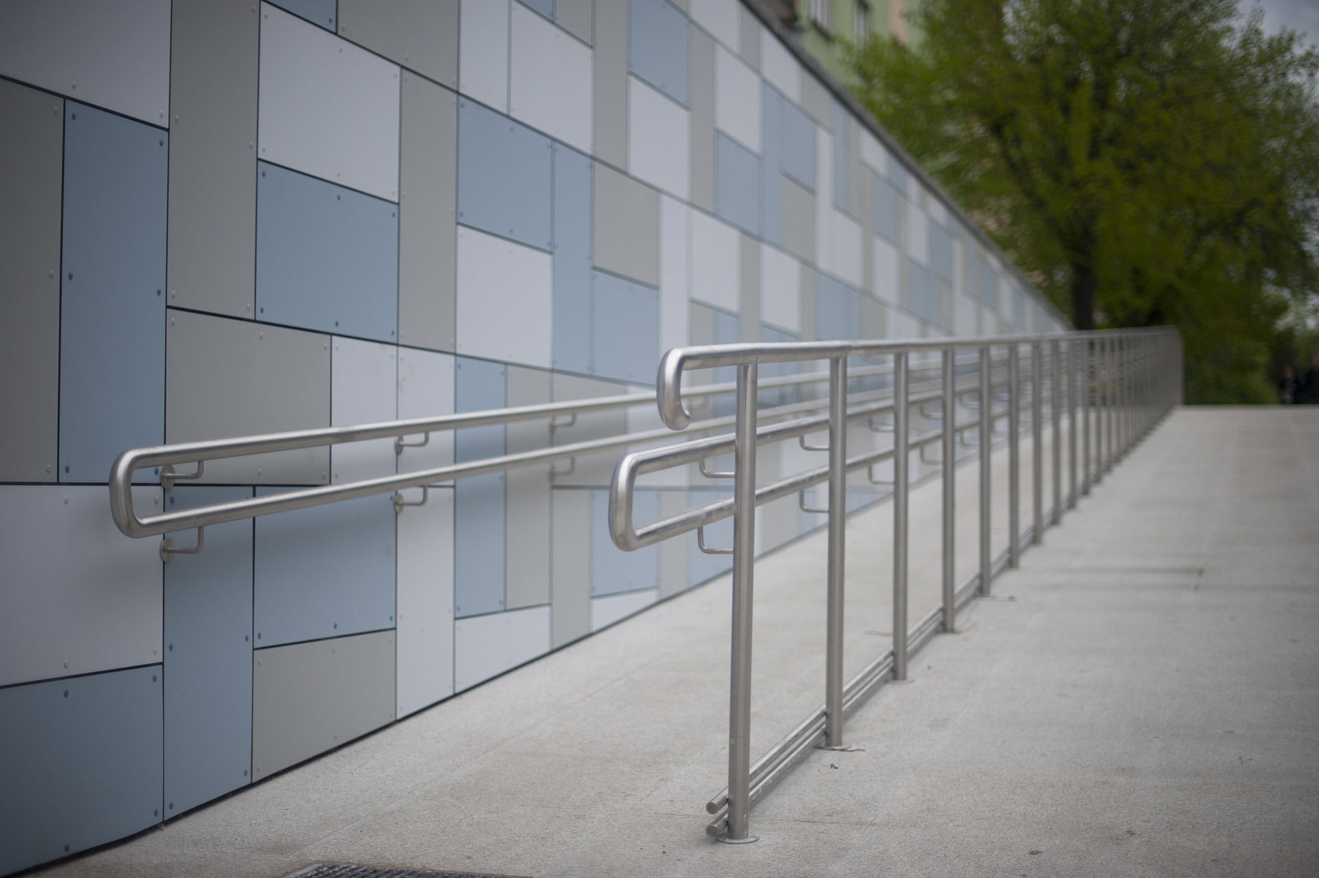 Photo of an access ramp with rails alongside the outside of a building