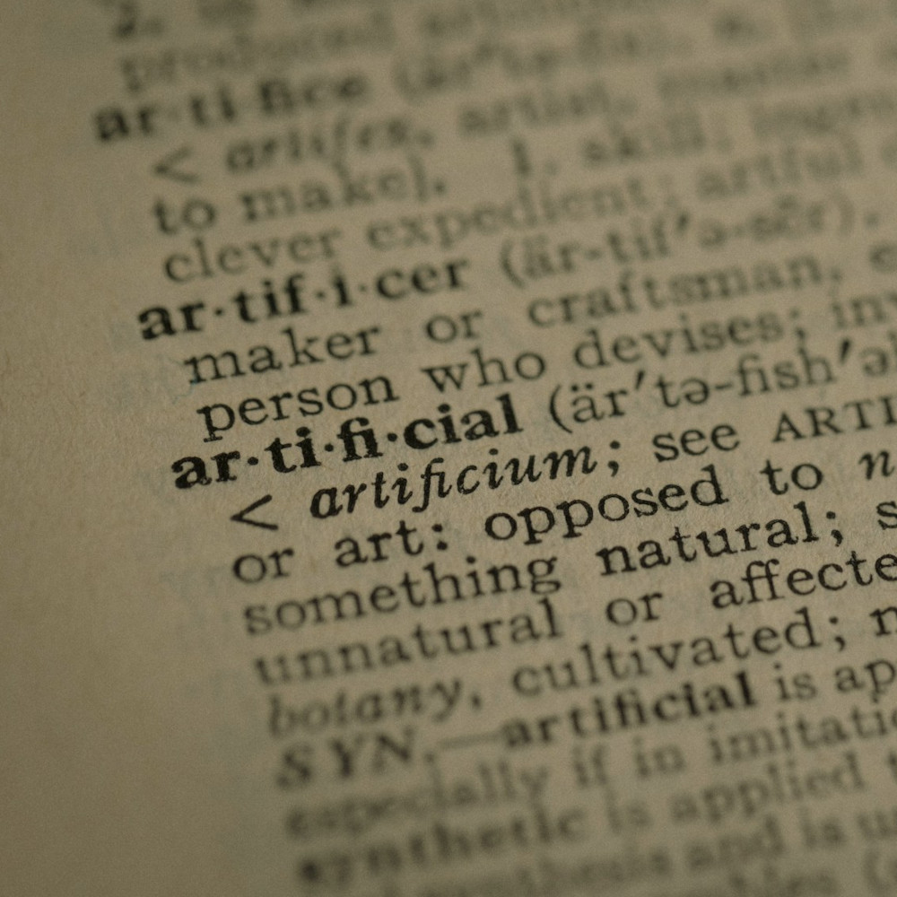 A close up of a dictionary with word "artificial" in focus